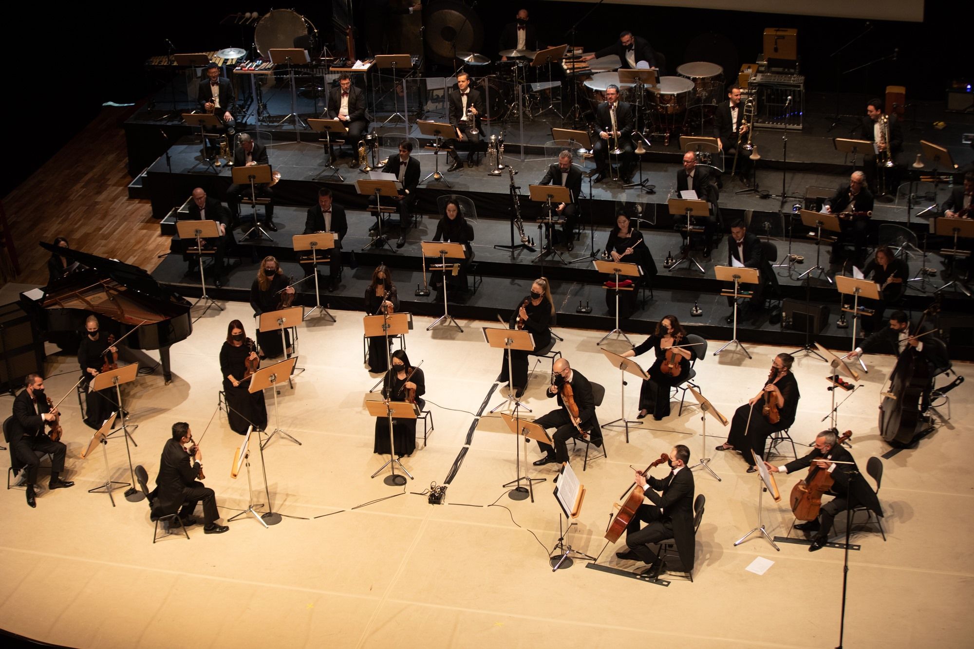 A symphony orchestra perform onstage at the opening concert for Qatar-USA 2021.