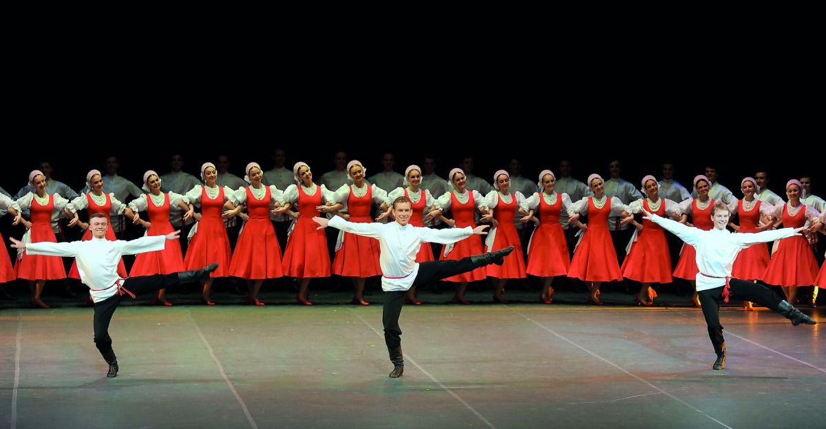 The Ilyev Ballet performs in Qatar, a chorus of dancers form a line behind three male lead dancers.