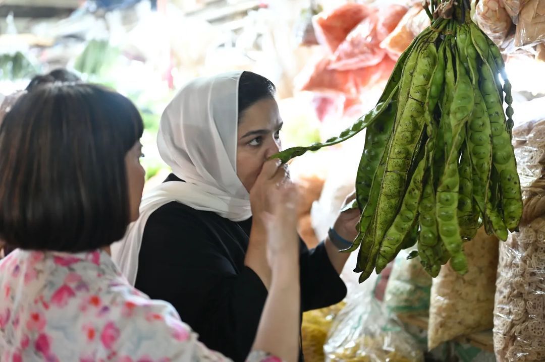 Qatari Chef Noof with Indonesian chef Santhi Serad at a local Indonesian market, choosing fresh ingredients.