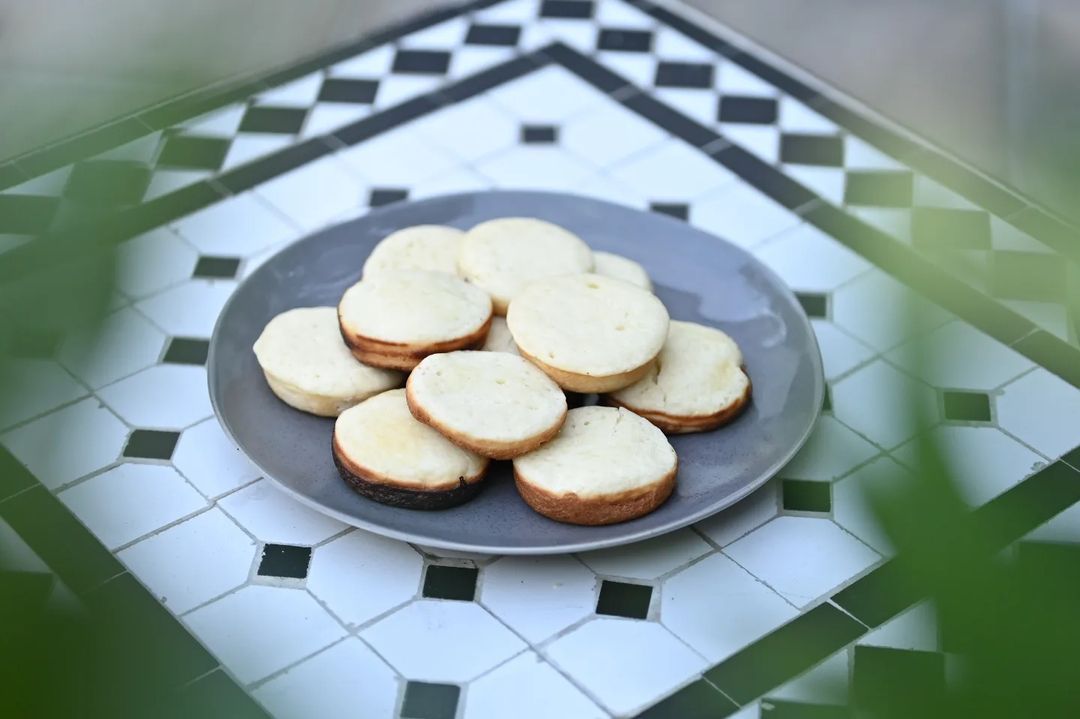 A plate of traditional Indonesian cakes, on a black and white tiled tabletop.