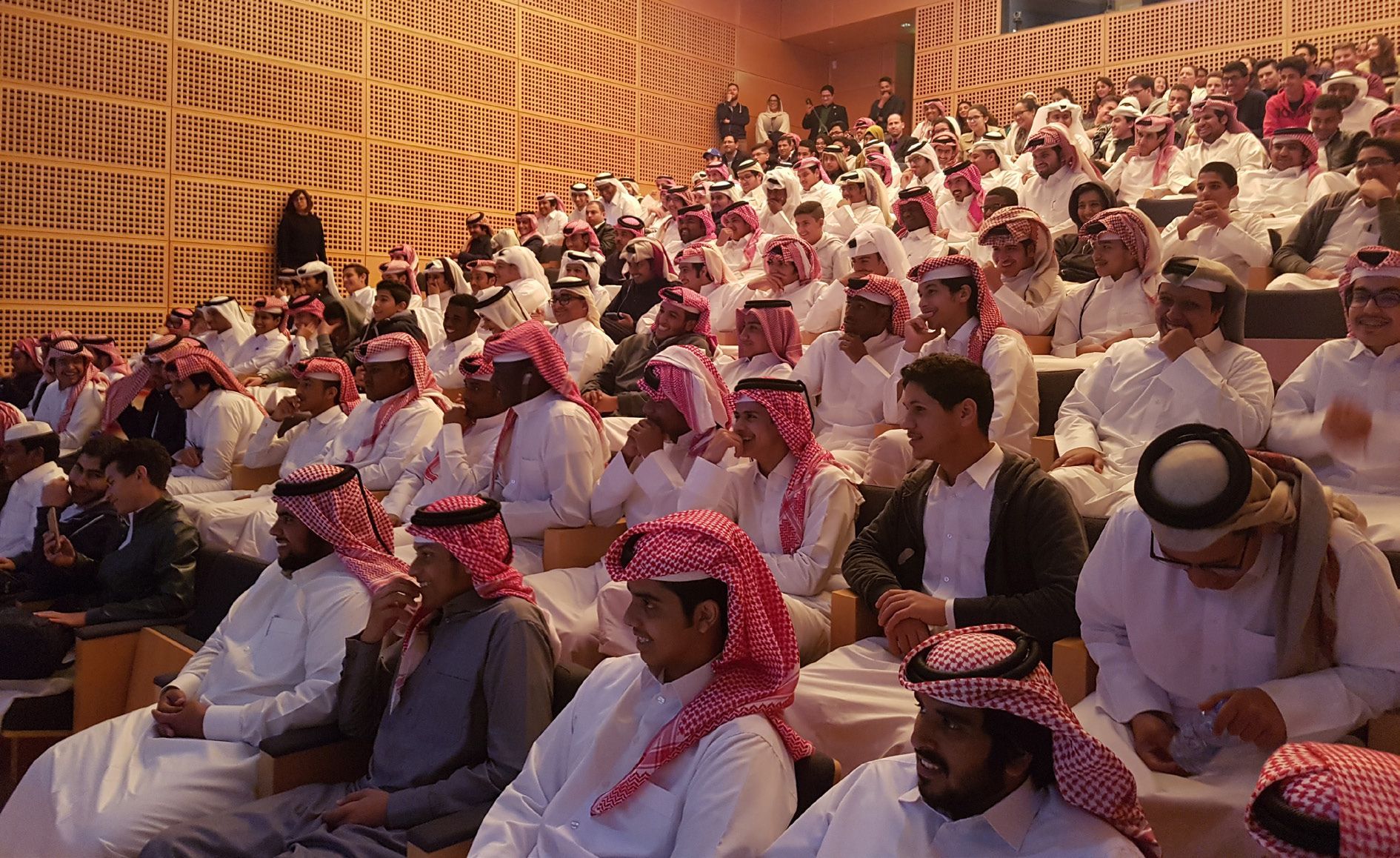 A cinema audience sit in tiered rows, during a film screening for German Film Week in Qatar.