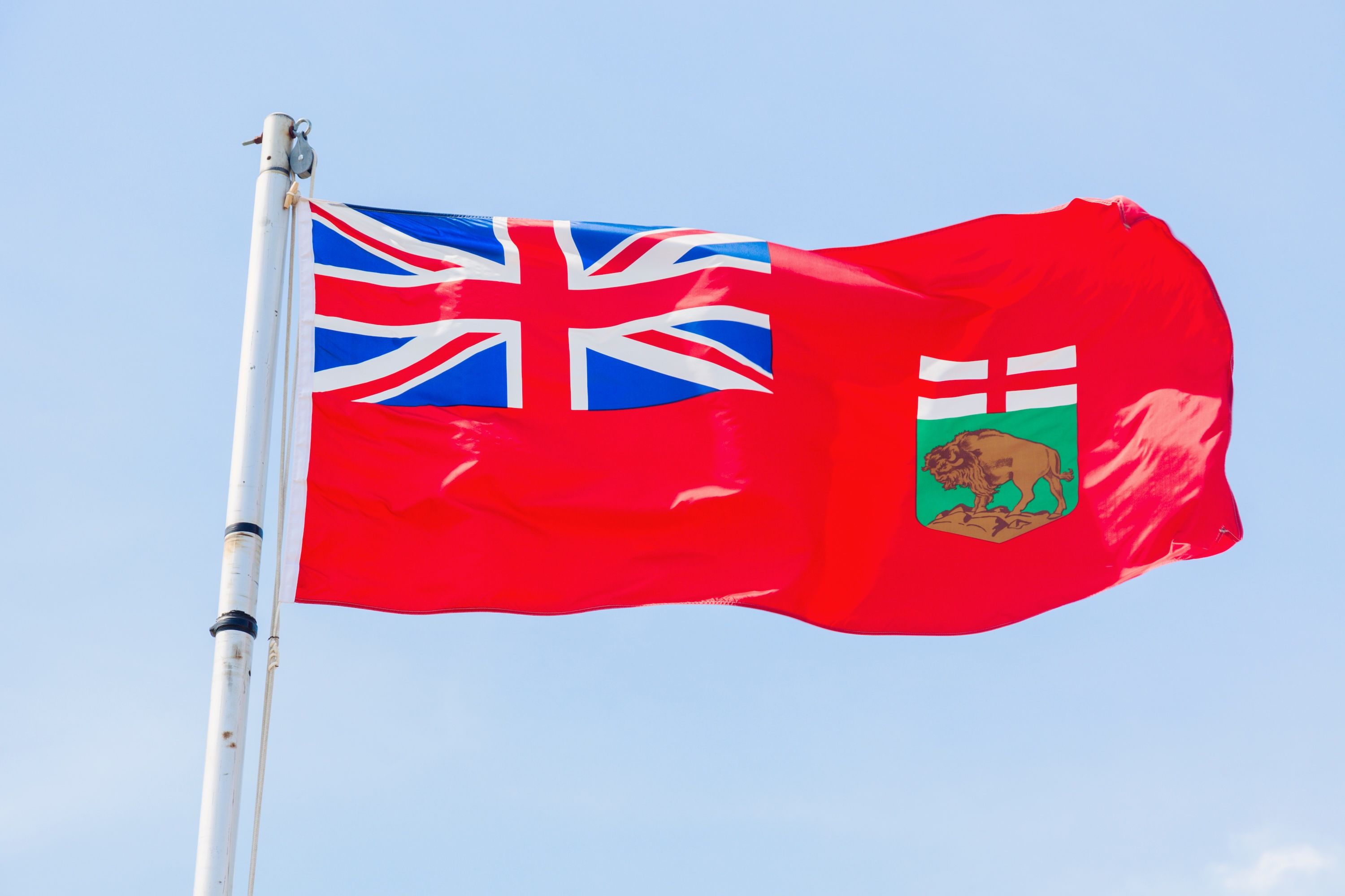Manitoba flag against blue sky