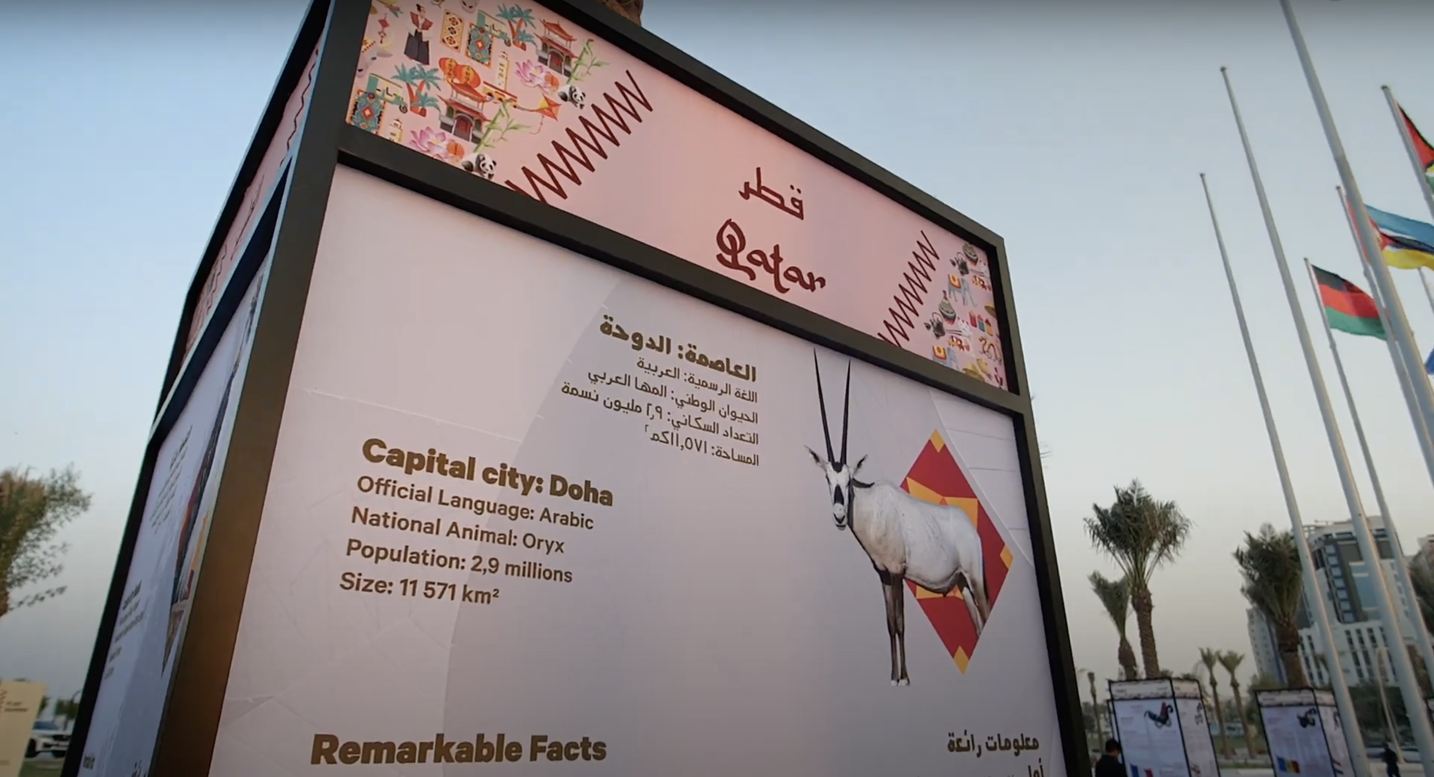 An information panel at Flag Plaza in Doha, depicting statistics and facts about Qatar in English and Arabic.