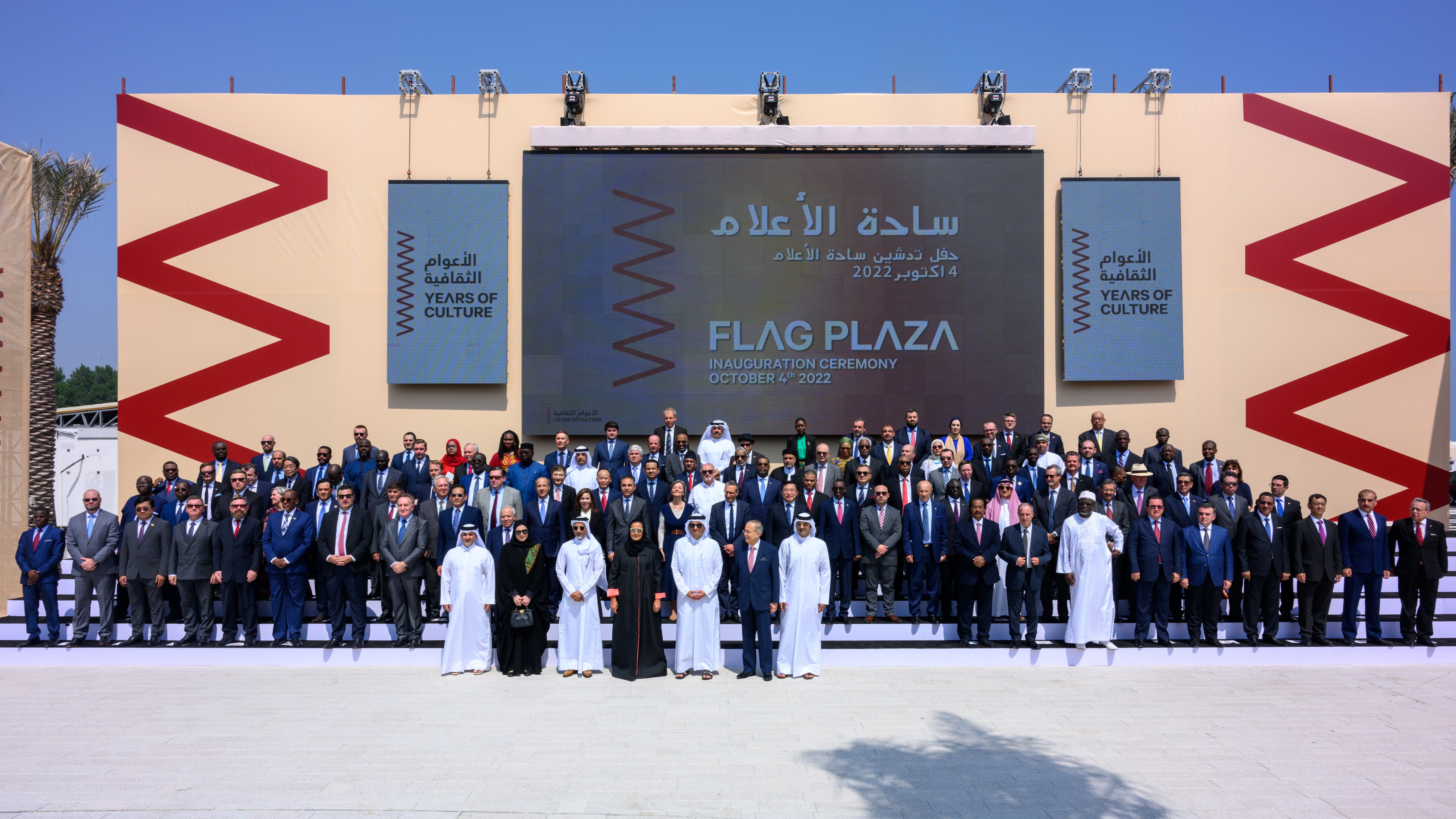 Over 100 important officials and guests standing against a Years of Culture backdrop at the Flag Plaza inauguration in Doha.