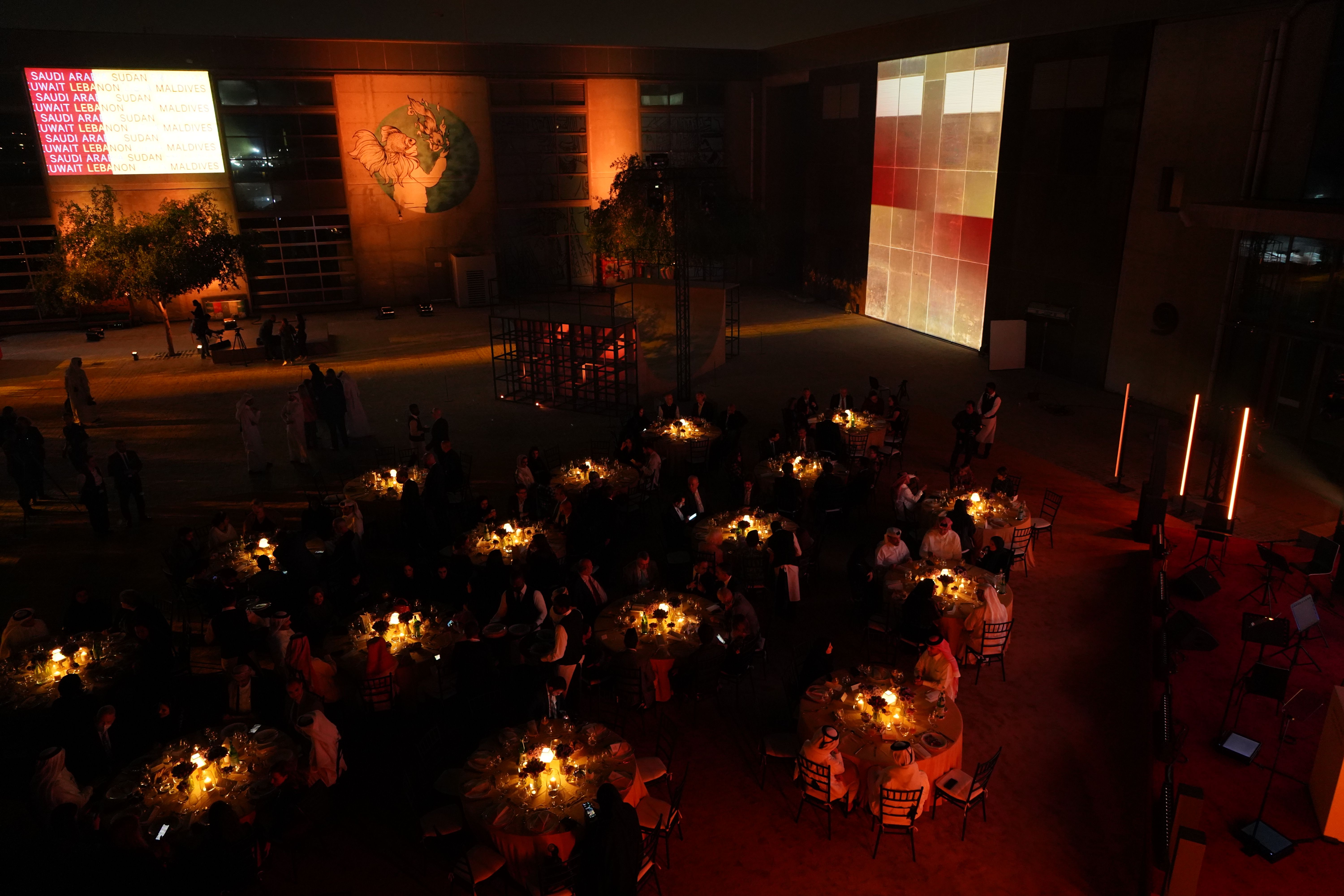 Outdoor courtyard of the Fire Station at night, set up with round tables for a formal dinner.