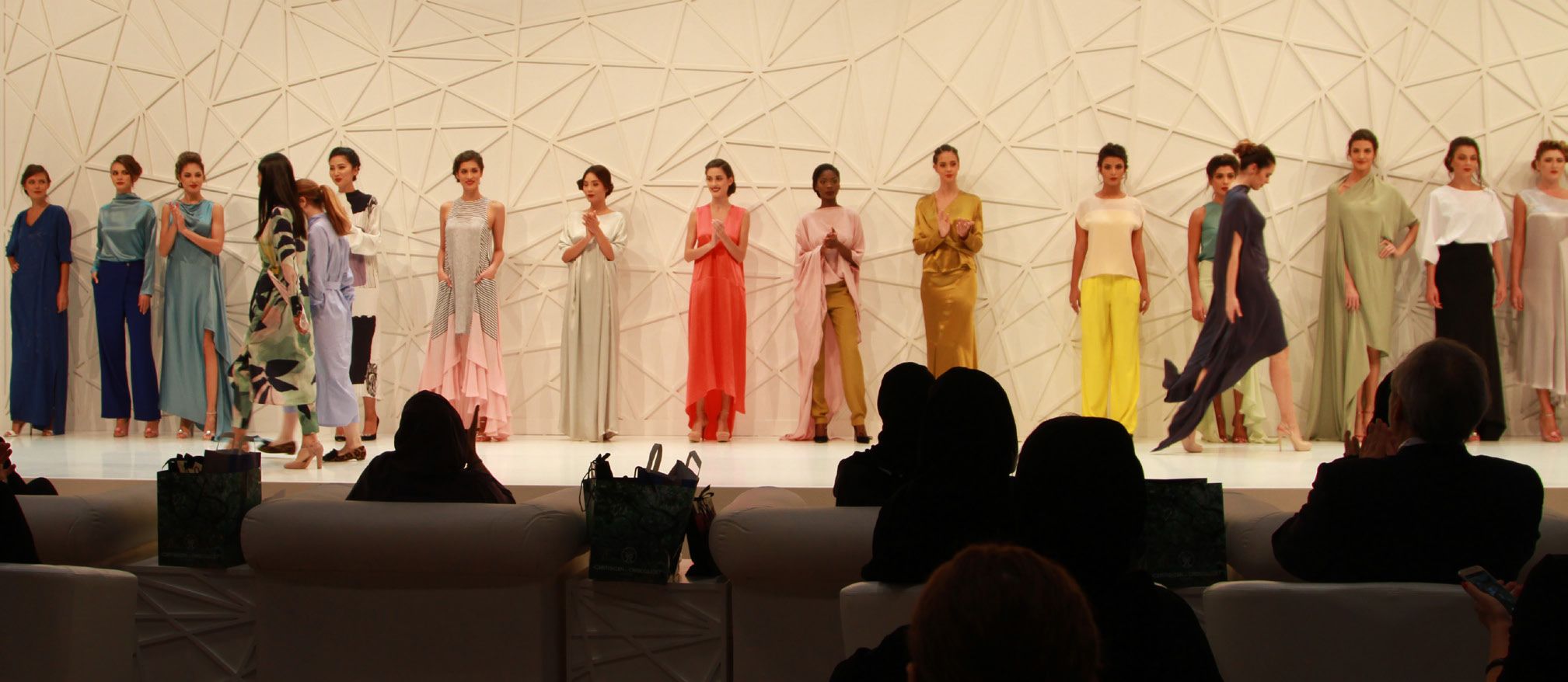 A line of around 20 models on stage during a catwalk for Heya Arabian Fashion Exhibition during Qatar-Germany 2017.