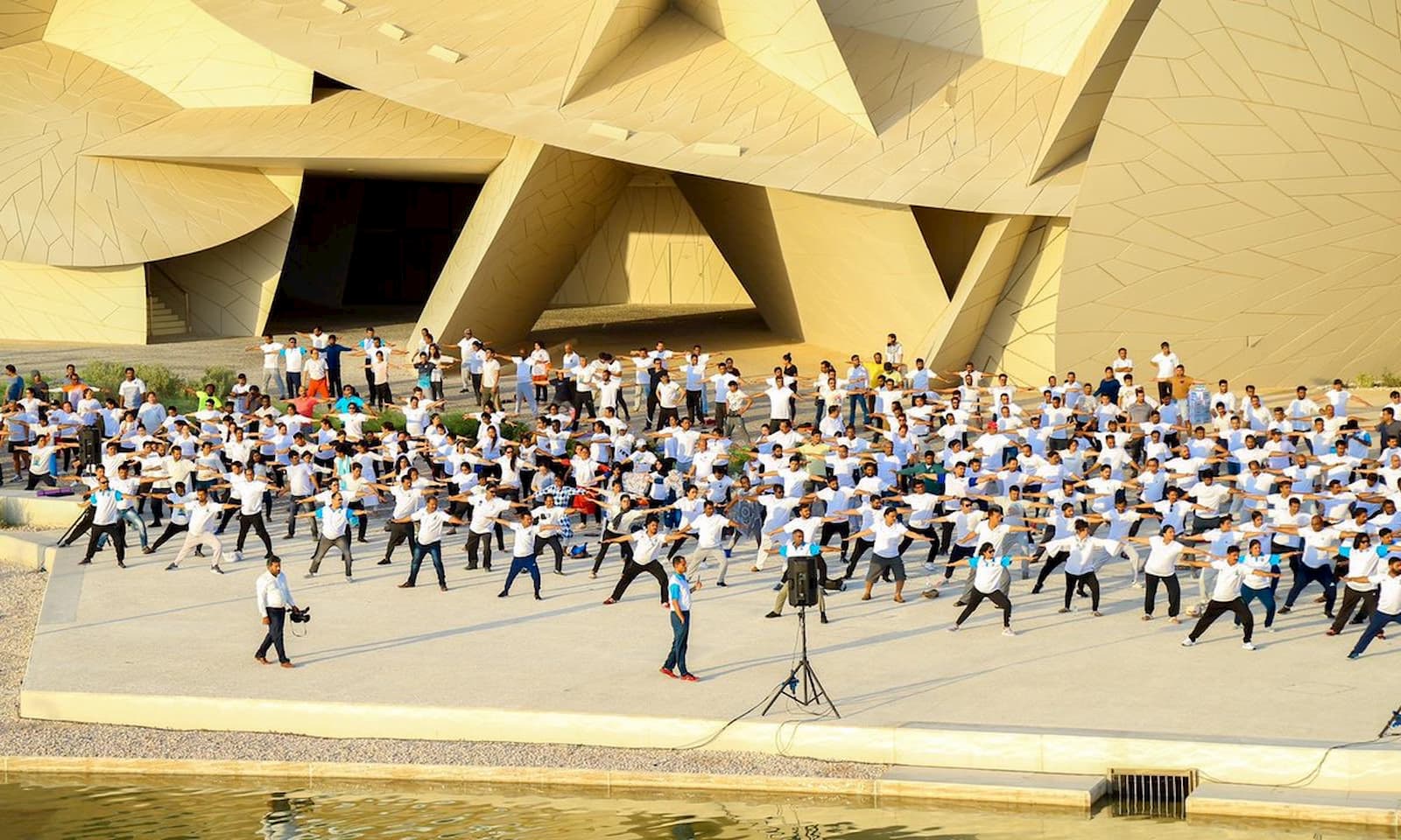 Hundreds of people take part in a yoga class for International Yoga Day at the National Museum of Qatar.