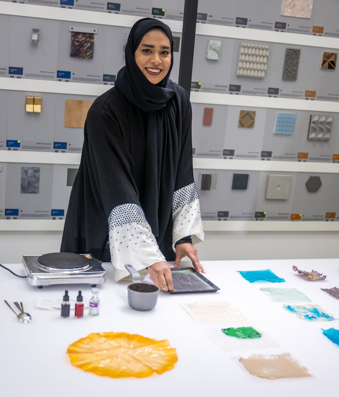 Qatari designer Rabab Abdulla stands behind her work station with materials for creating bio plastics.