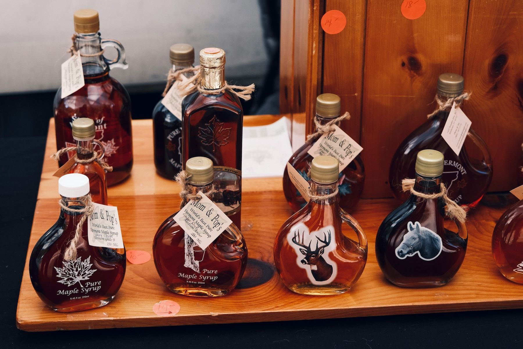 several bottles of maple syrup of different colours and shapes