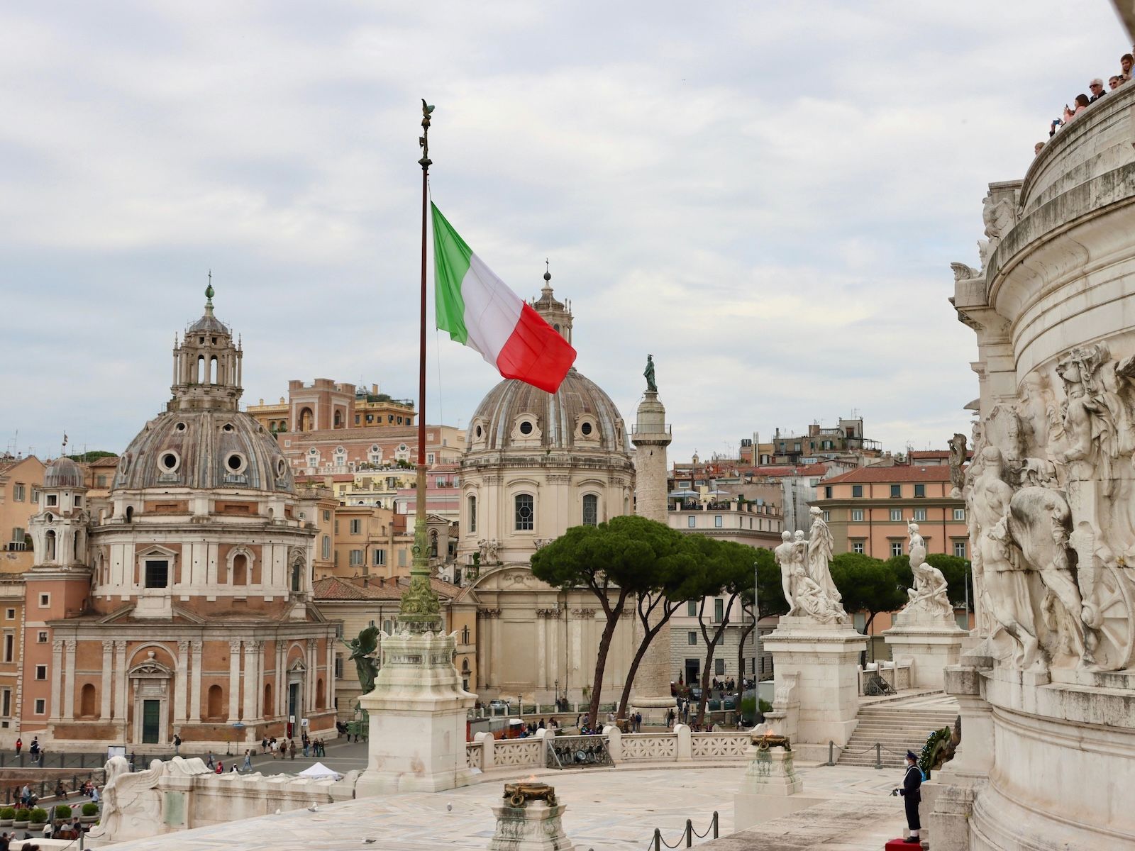 "italian flag flying on a flagpole in front of the Vittoriale in Rome