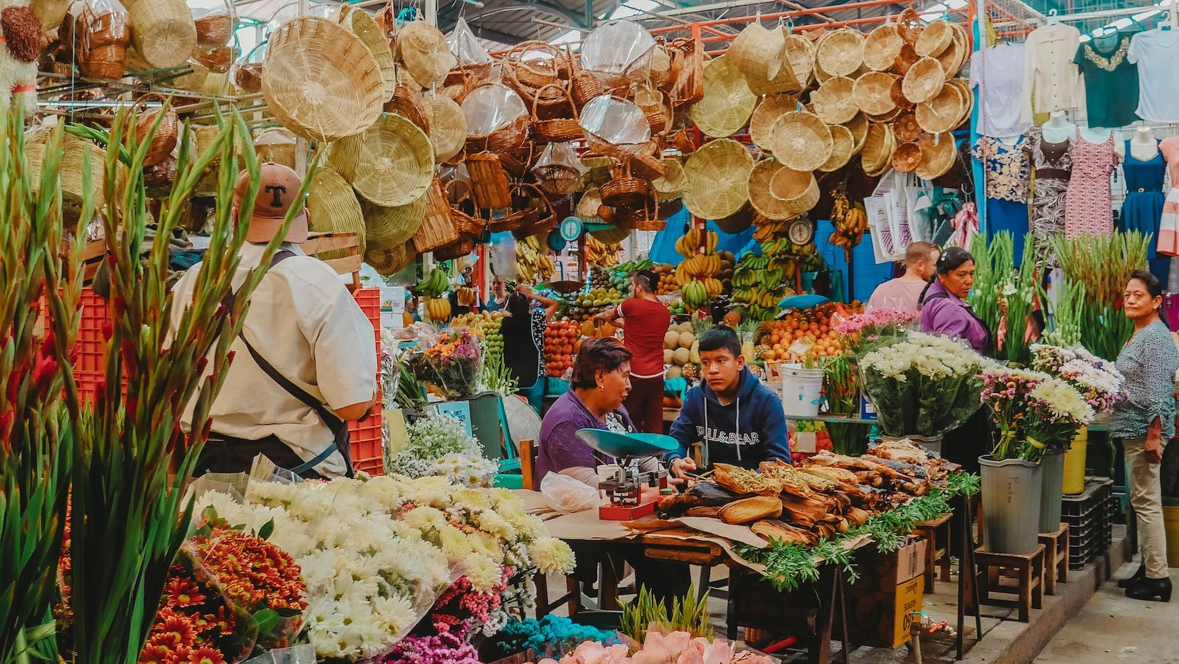 A vibrant moment inside a traditional market in Mexico City. Market stalls are full of handmade crafts, produce and delicious Mexican food.