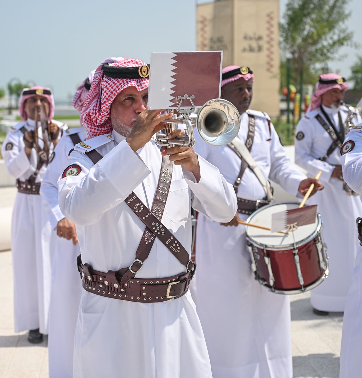 A Qatari marching band plays music on drums and brass instruments at the Flag Plaza inauguration in Doha.