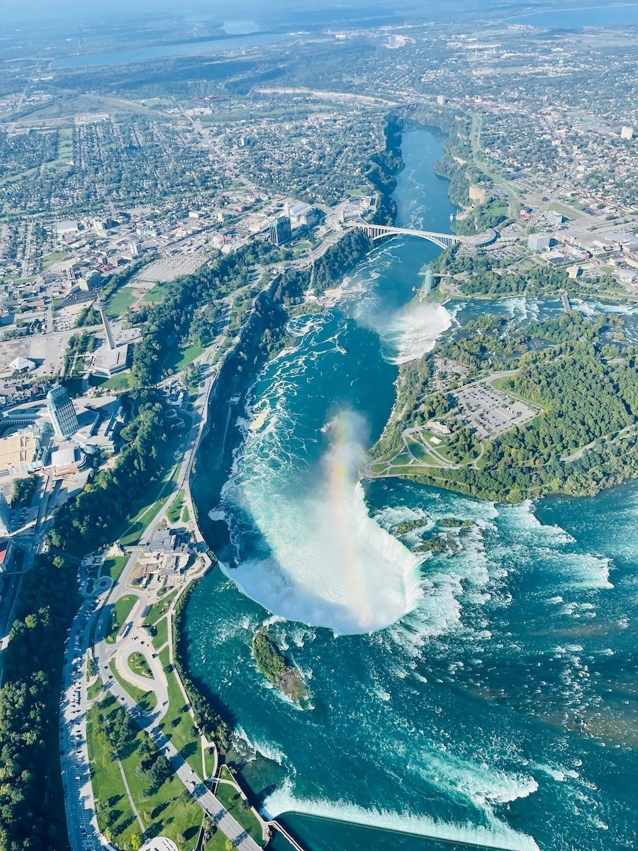 A large aerial view of Niagara Falls, showing all the three waterfalls that straddle the border between the U.S. and Canada.