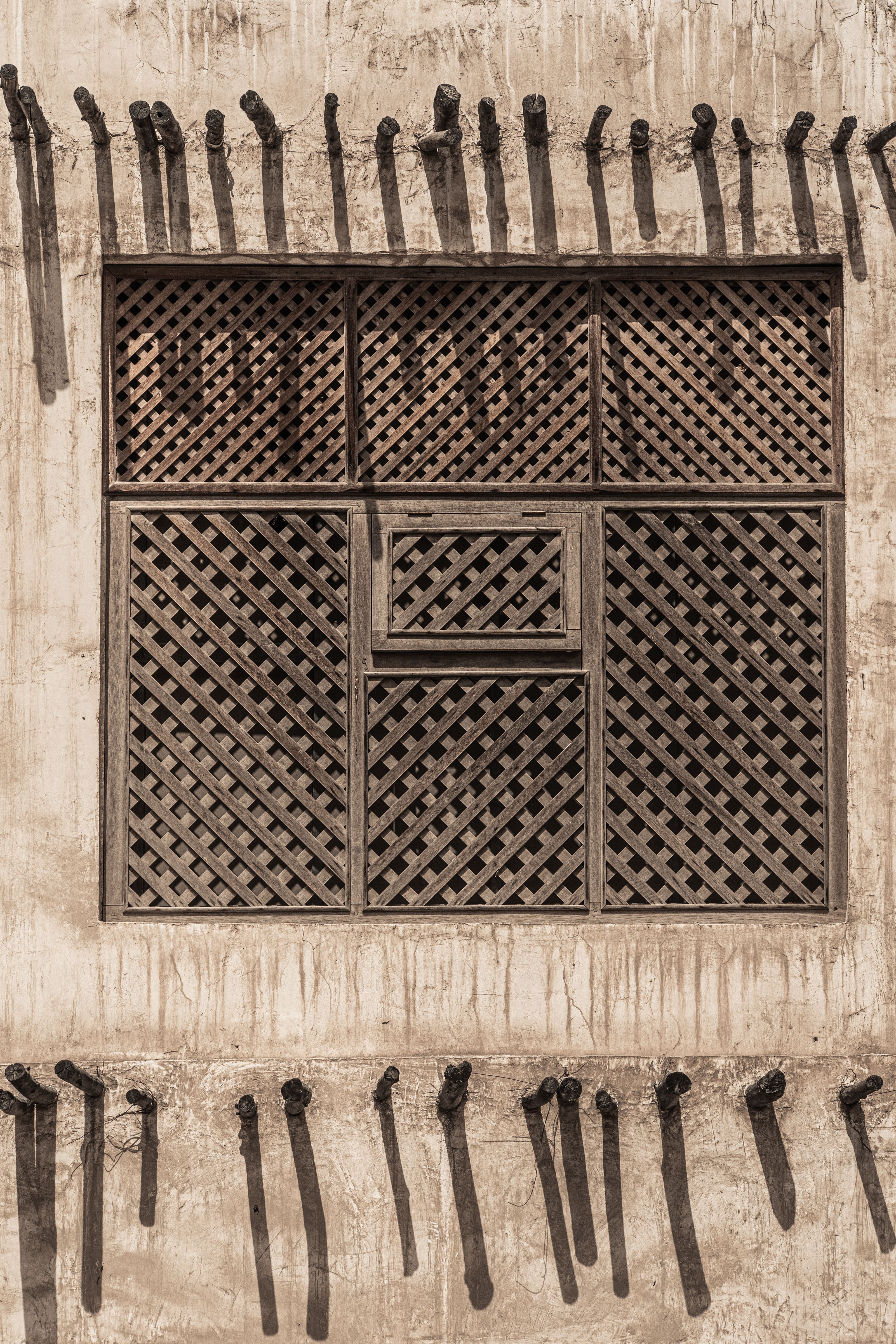 A historic Qatari window covered in wooden lattice, captured during the QATAR-USA 2021 Photography Exchange.