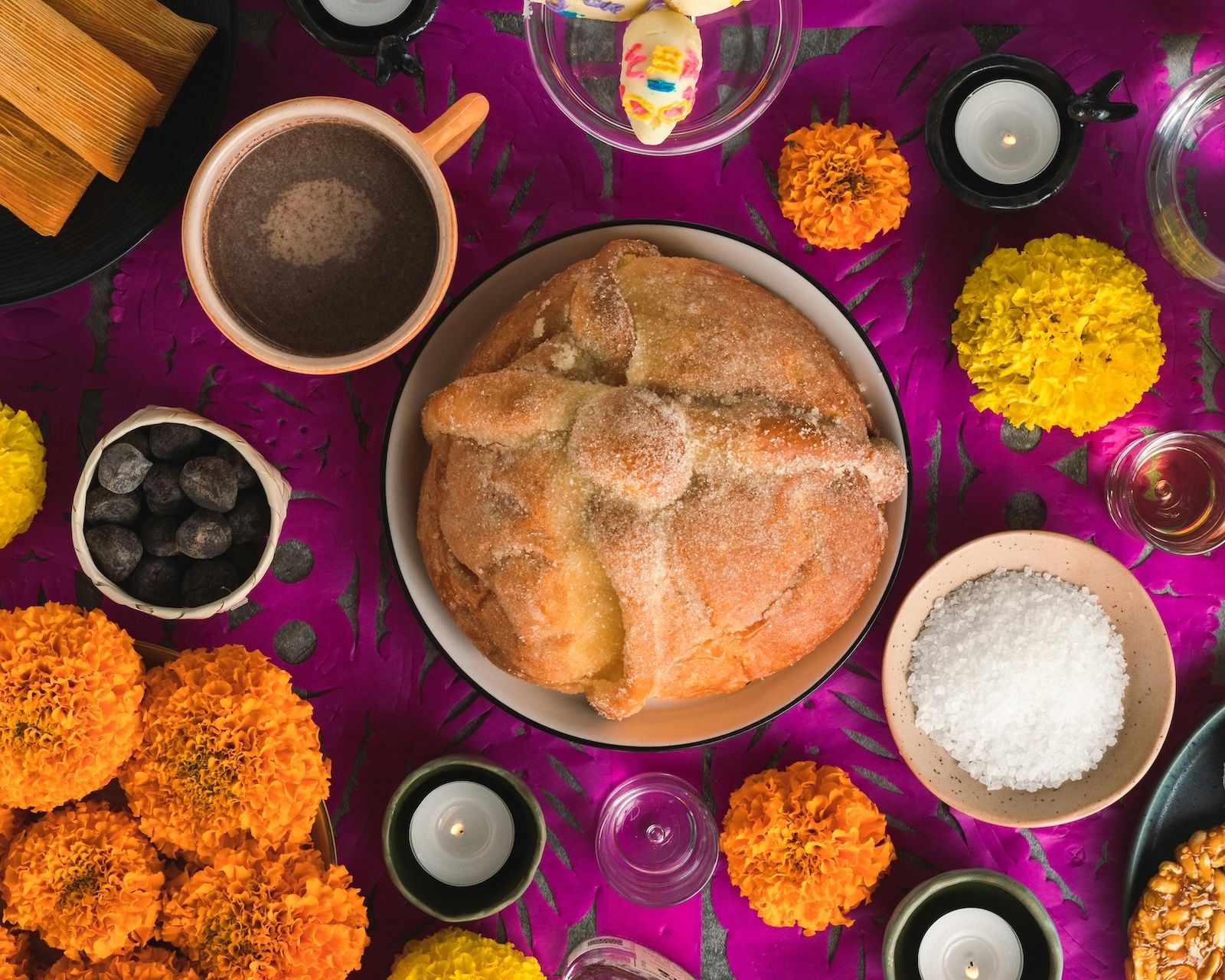 A traditional Día de Muertos altar, with Pan de Muerto, Cempasúchil and other ofrenda elements typical of this Mexican tradition.