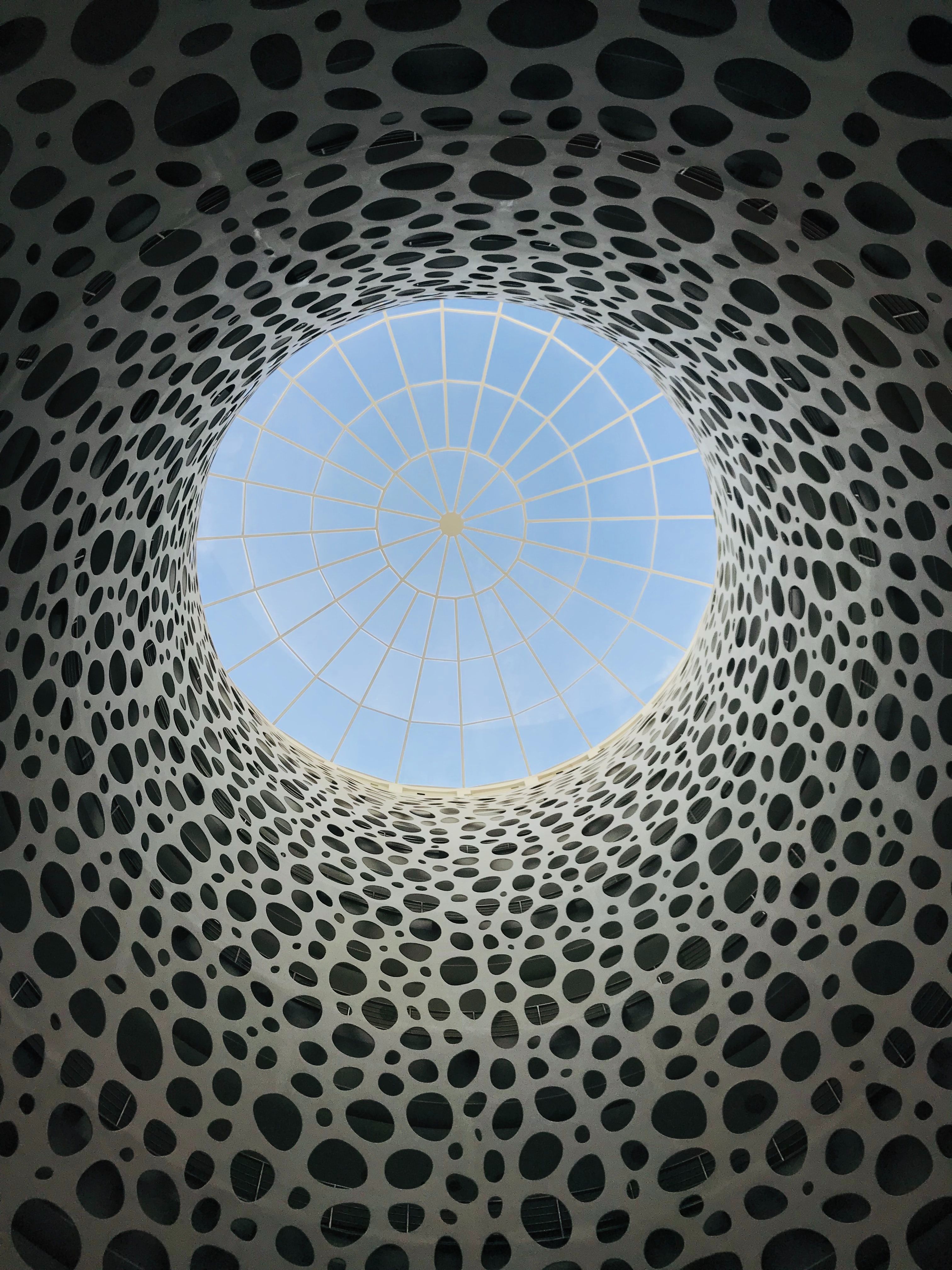 الهندسة المعمارية المعاصرة في قطر مع كوة زجاجية محاطة بجدران فنية منقوشة.