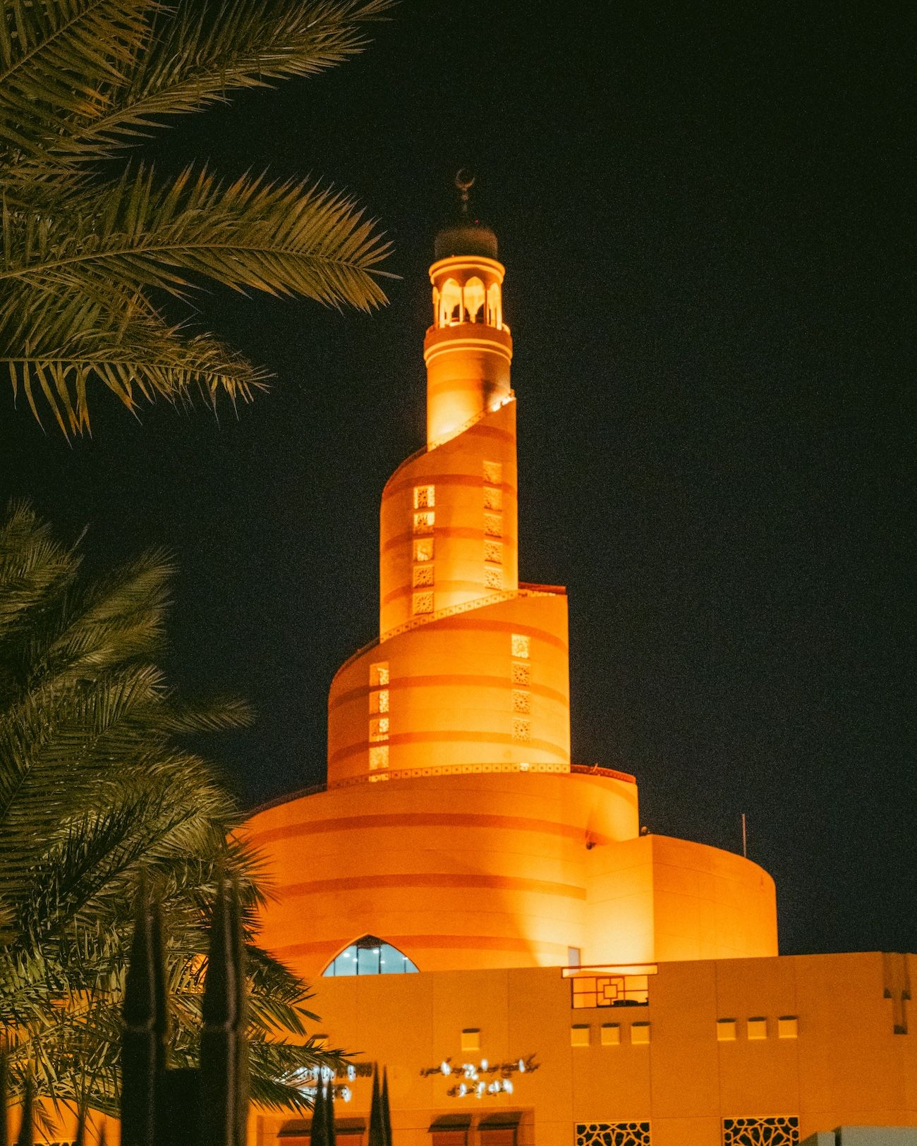 The Abdulla Bin Zaid Al Mahmoud Islamic Cultural Center, also known as the Fanar Mosque or Spiral Mosque, in Doha, captured at night.