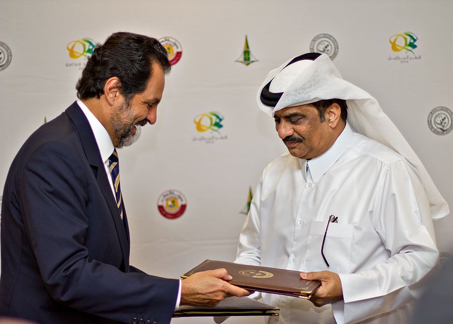 A Qatari official exchanges a signed agreement with a Brazilian official for Doha and Brasilia to become Sister Cities.