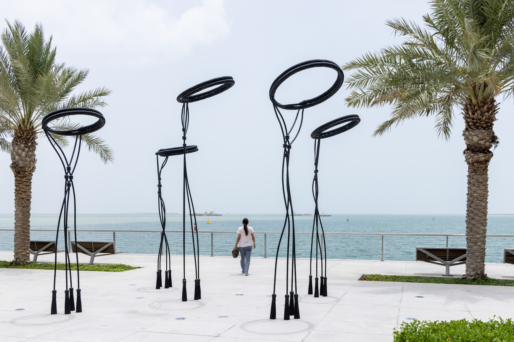 Contemporary sculptures by artist Shouq Al Mana depicting traditional Qatari headwear by the sea at Lusail Marina Promenade.