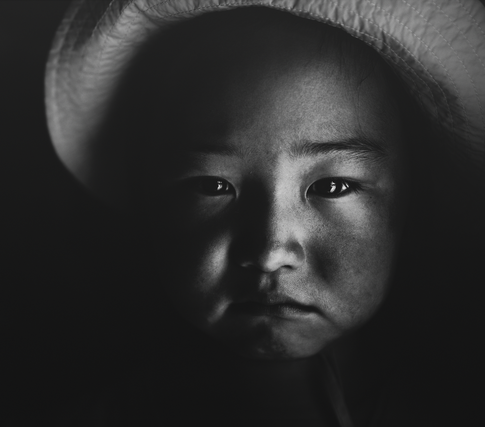 Portrait of a small child's face in black and white with atmospheric lighting from the Qatar-China 2016 Year of Culture.