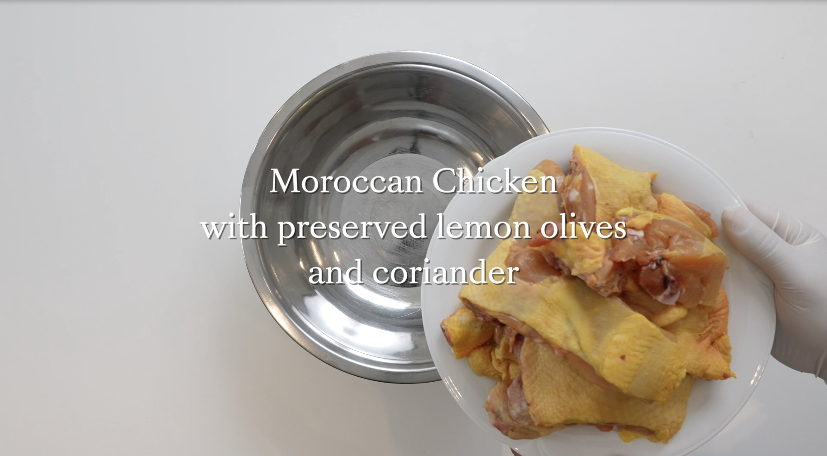 A plate of chopped raw chicken and a mixing bowl ready to prepare Sami Tamimi's Moroccan Chicken recipe.