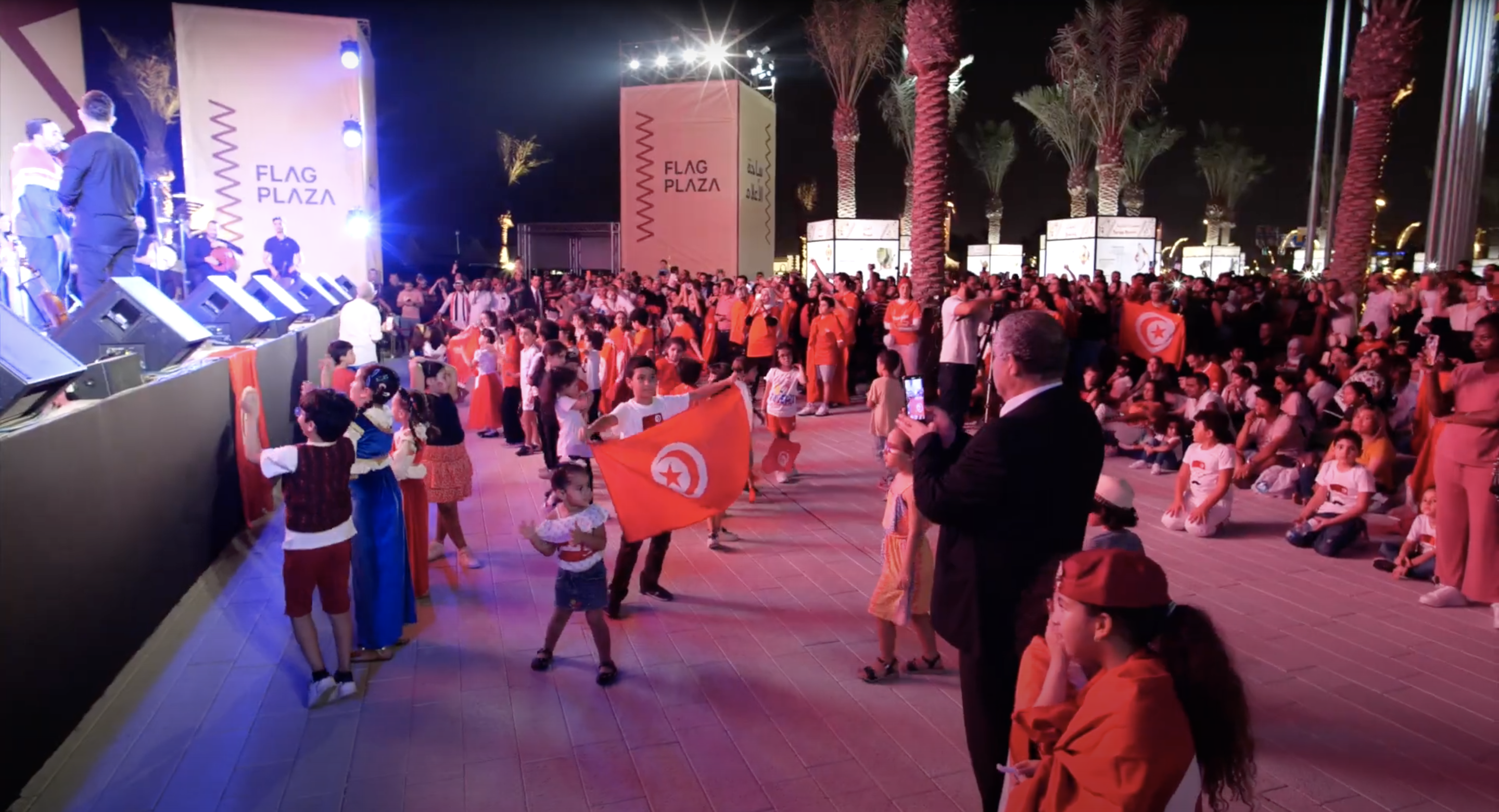 A crowd watch a performance on an outdoor stage at Flag Plaza in Doha, Qatar during the Community Festival 2022.