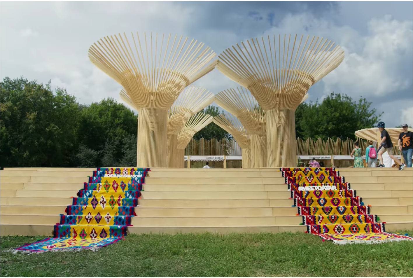 Two rows of wooden sculptures resembling trees at the top of a staircase at Afisha Picnic in Russia.