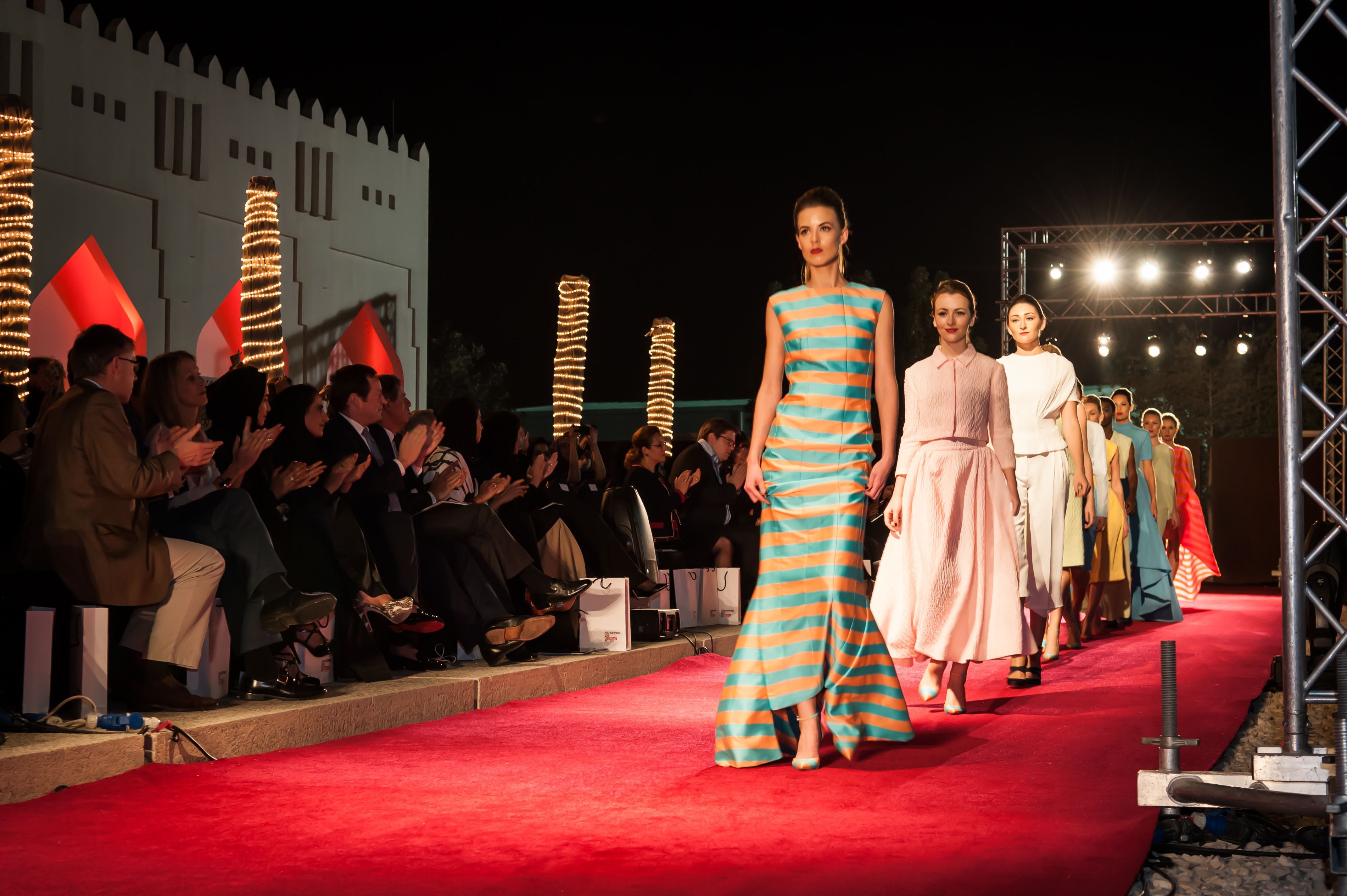 Models wearing evening dresses walk on a red catwalk during the Qatar - UK 2013 Fashion Exchange.