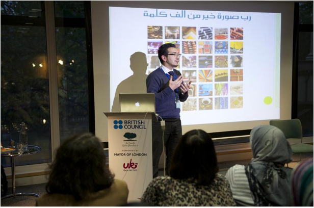 A man gives a presentation at a lectern in front of a small audience during Qatar-Uk 2013.