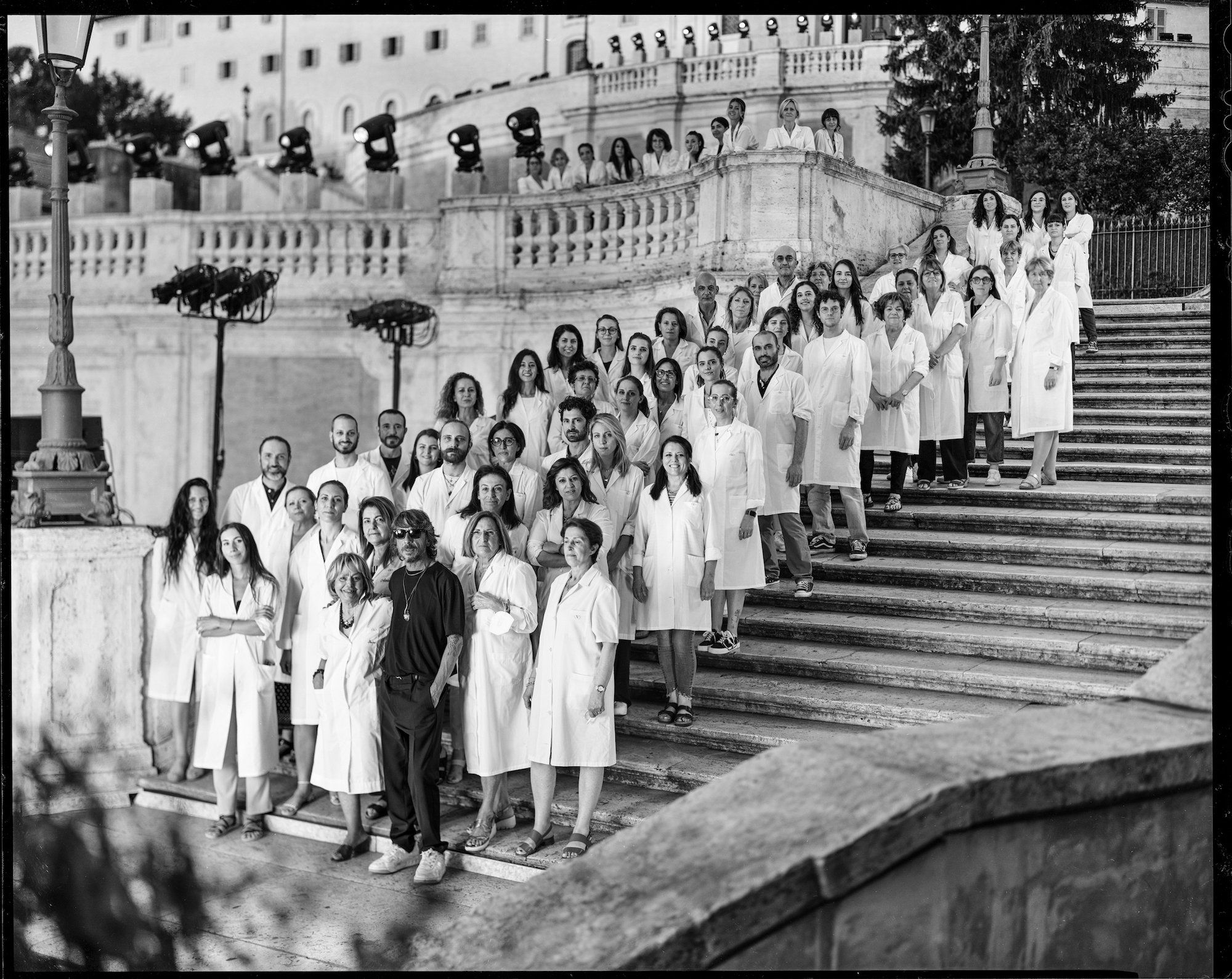 Black and white group portrait on the Spanish steps in Rome, part of the Forever Valentino Exhibition at M7 in Doha.