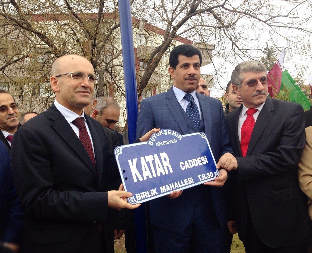 3 men in suits hold a street sign named after Qatar in Istanbul in celebration of the Qatar-Turkey 2015 Year of Culture, 