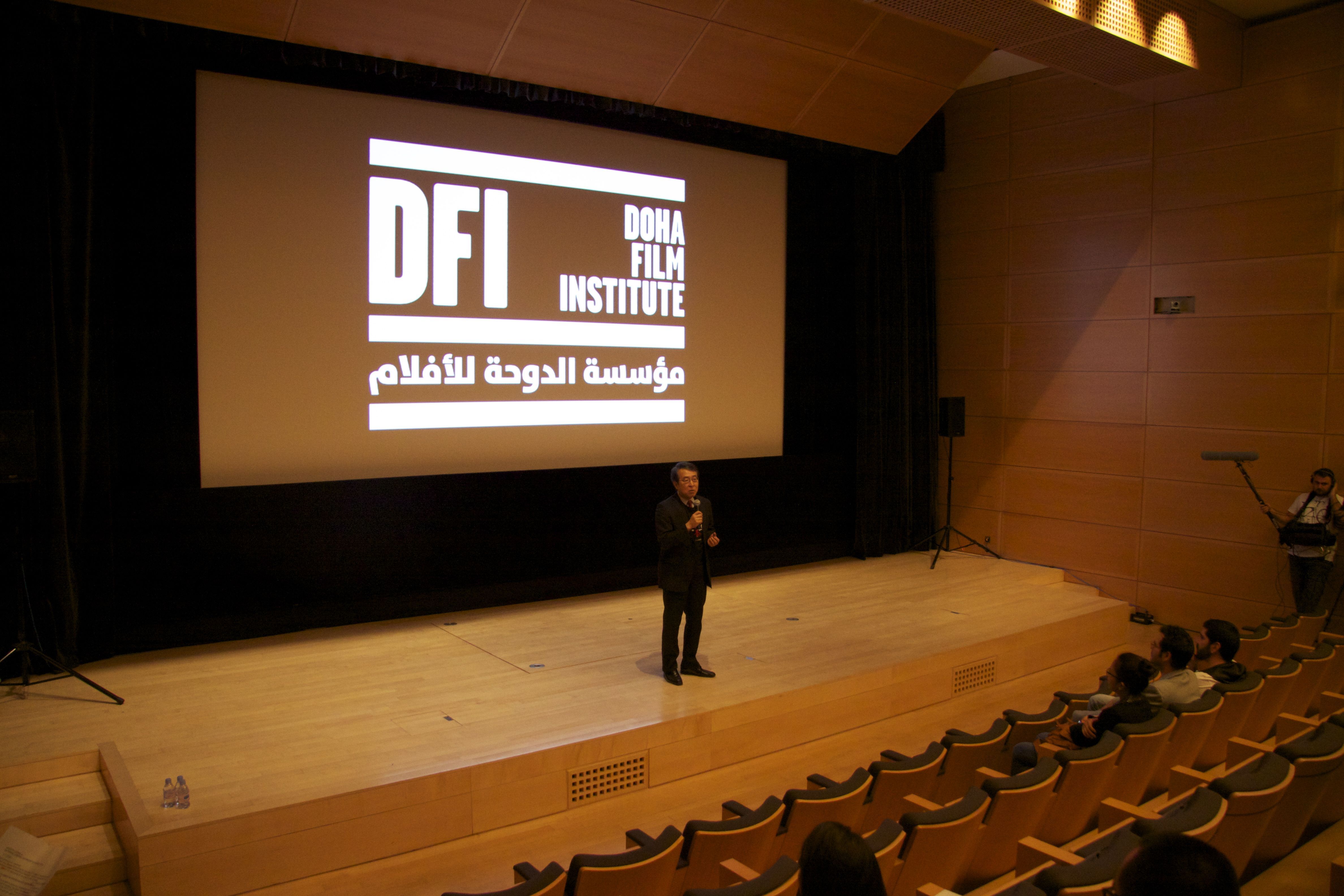 Japanese man speaks into a microphone onstage during the Doha Film Institute Japanese Cinema Showcase.