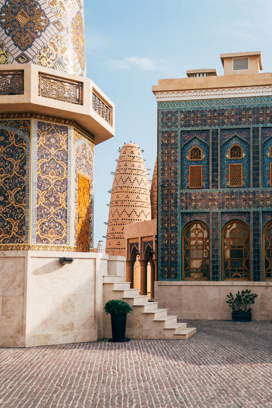 A corner of Katara Cultural Village with ornate facades of the blue mosque and one of the pigeon towers in the background.