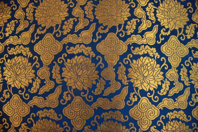 Golden thread embroidery on a blue silk background, panel of fabric on display at the Chinese Silk exhibition in Doha.
